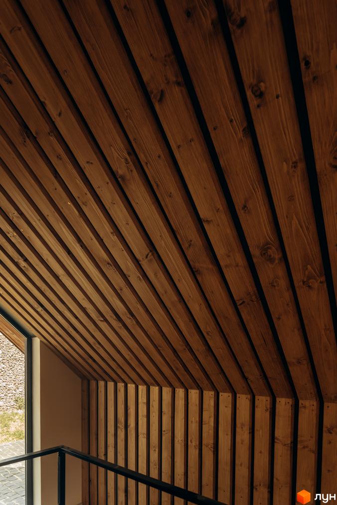 Дизайн інтер'єру житлового комплексу КМ Gutenberg з дерев'яними елементами на стінах та стелі. Зовнішній вигляд будинку з натуральних матеріалів.