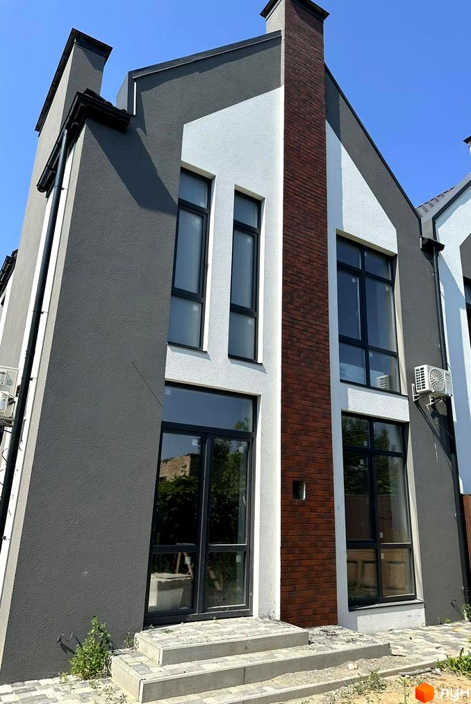 Фасад таунхауса Карамель з цегляним елементом та великими вікнами. Поруч розташована бруківка та сходи.
