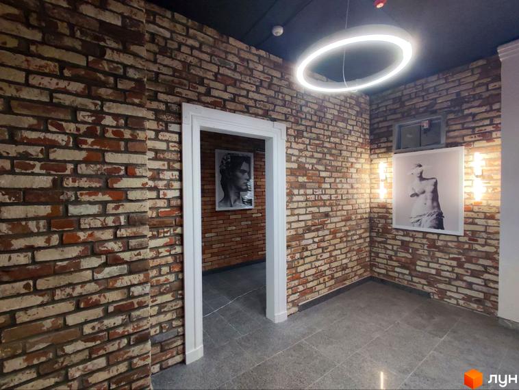Житловий комплекс Loft White. Інтер'єр з цегляною стіною та картиною.