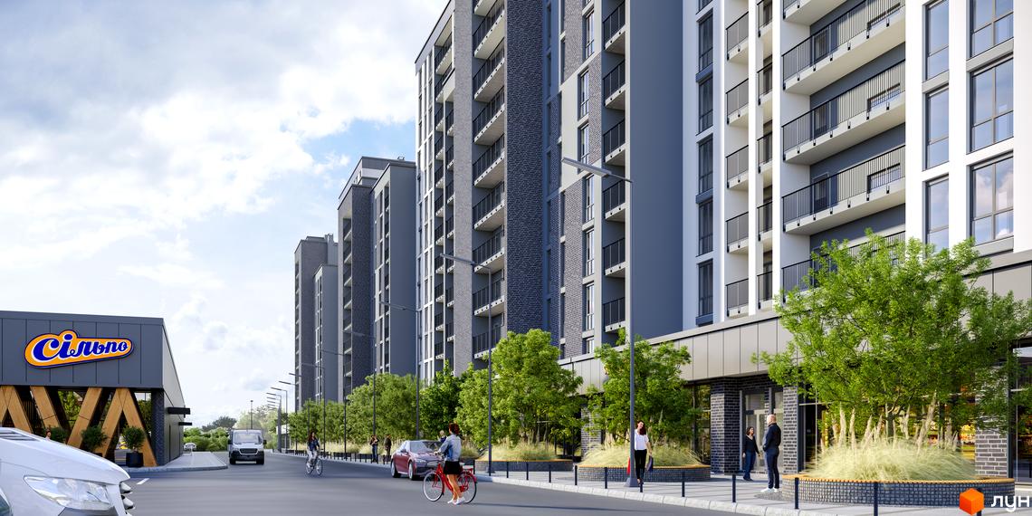 Житловий комплекс Щасливий Grand з сірими фасадами та балконами, прибудинкова територія з деревами та дорогою.