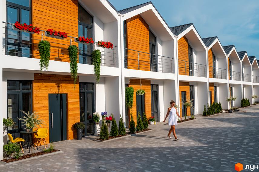 Зовнішній вигляд будинків у Котеджному містечку Prydesennya Eco Village. На території біля будинків висаджені декоративні рослини.