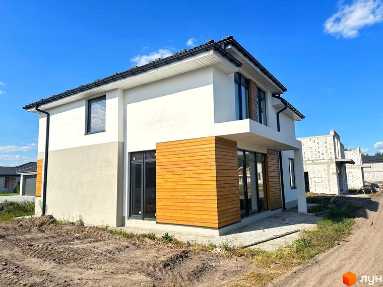Зображення будинку в Котеджному містечку Prydesennya Eco Village. Двоповерховий будинок з дерев'яним оздобленням фасаду та великими вікнами.