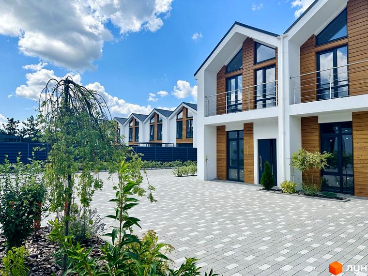 Зображення Котеджного містечка Prydesennya Eco Village: двоповерхові будинки з дерев'яним оздобленням та великі вікна. Облаштована прибудинкова територія.