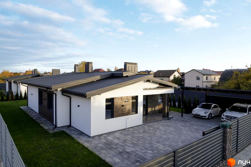 Котеджне містечко КМ New Village: одноповерхові будинки з пласкими дахами та прибудинковою територією з навісом для автомобілів та бруківкою.