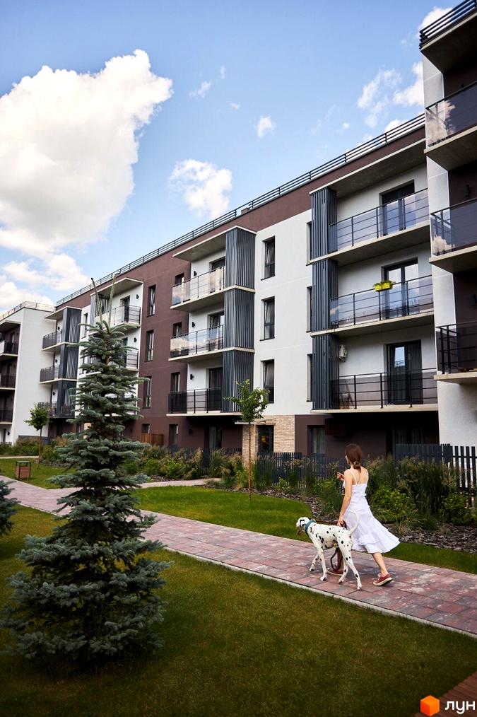 Зовнішній вигляд Житлового комплексу StyleUP з балконами. На території зелені насадження та пішохідна доріжка.