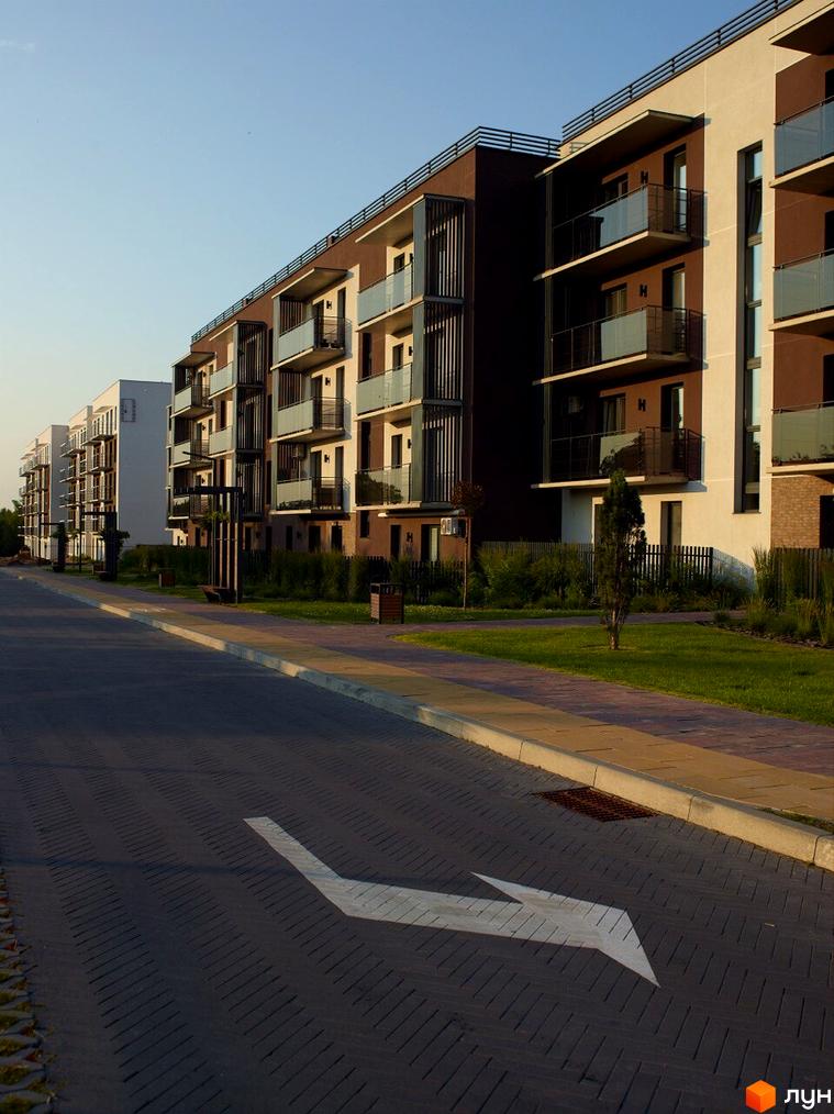 Зображення Житлового комплексу StyleUP з фасадом з балконами та прибудинковою територією з газоном та пішохідною зоною.