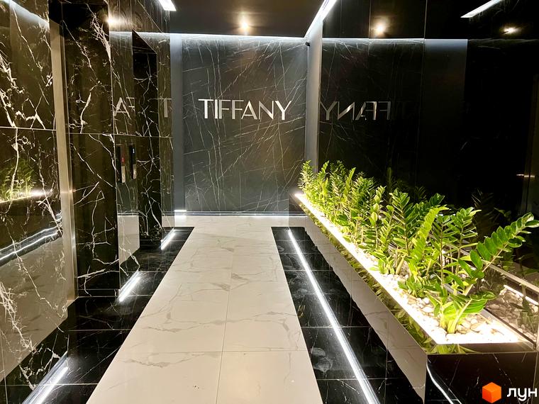 Вхідна група житлового комплексу Tiffany з мармуровим оздобленням та рослинами. Сучасний дизайн холу новобудови Tiffany.