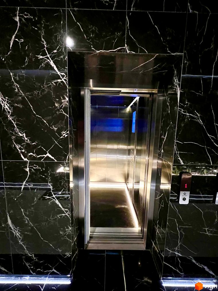 Сучасний ліфт у житловому комплексі Tiffany з чорним мармуром та підсвіткою. Ознайомтеся з елегантним дизайном інтер'єру новобудови Tiffany.