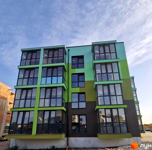 Фасад новобудови ЖК Квітковий з вікнами та балконами. Будівельний проєкт з яскравим оздобленням фасаду.