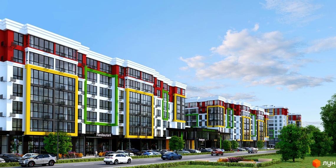 Багатоповерховий будинок з кольоровим фасадом та великими вікнами. На першому поверсі розташовані комерційні приміщення, перед будинком дорога з припаркованими машинами.