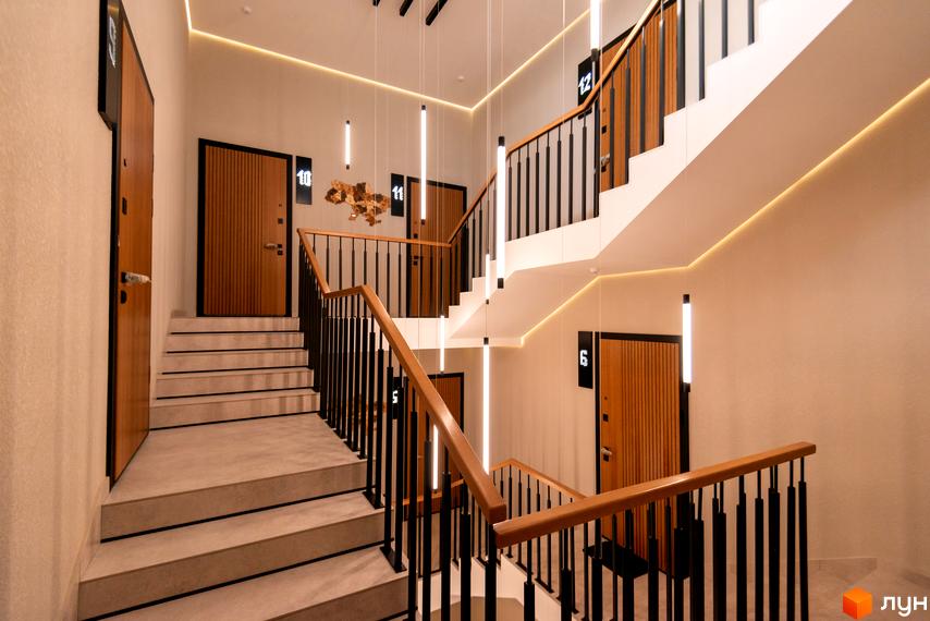 Дизайн сходової клітки в новобудові ЖК SHERWOOD з дерев'яними дверима та підсвіткою. Сучасний інтер'єр місць загального користування.