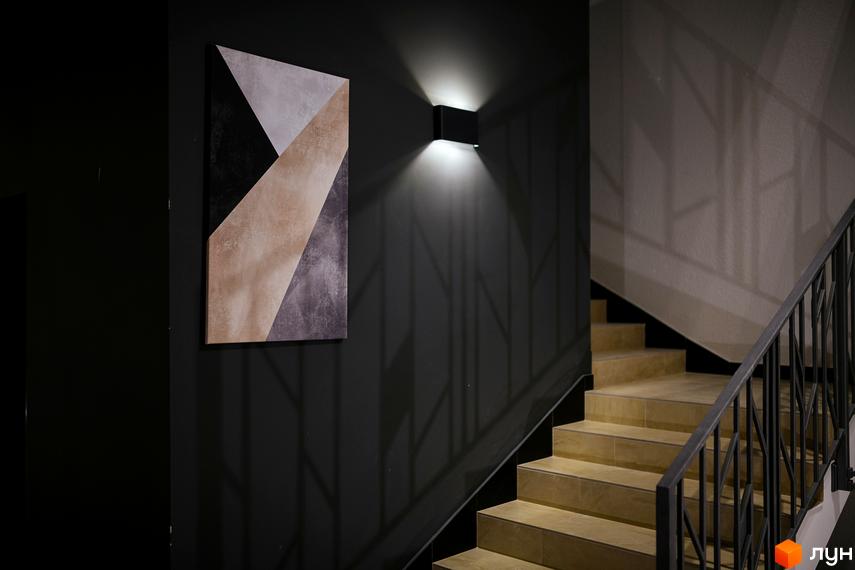 Інтер'єр сходової клітини ЖК DREAM CITY з абстрактним панно на стіні та підсвічуванням. Сходи оздоблені плиткою, поручні металеві.