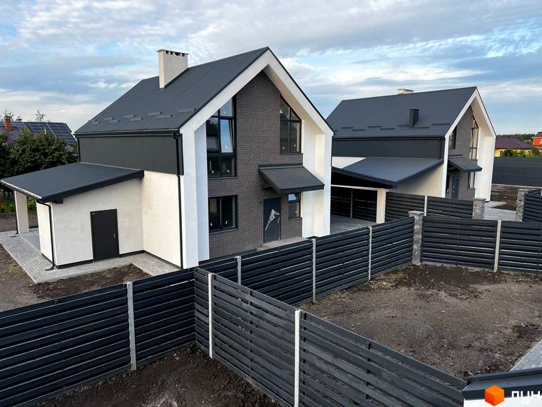 Котеджне містечко КМ New Village: двоповерхові будинки з темним дахом та білими стінами, огороджені парканом. Навколо будинків облаштована прибудинкова територія з доріжками.