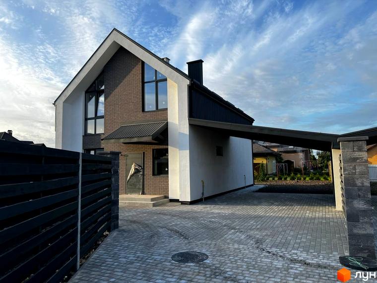 Котеджне містечко КМ New Village. Фасад будинку з цегли та білої штукатурки, навіс для авто, вимощена бруківкою територія.