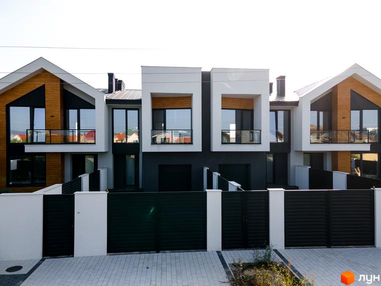 Таунхауси „ШЕВЧЕНКА“: фасади з дерев'яними елементами та великими вікнами. Прибудинкова територія з парканом та воротами.