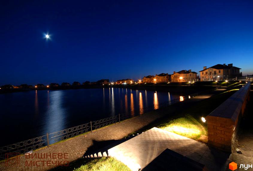 Котеджне містечко КМ Вишневе містечко вночі. Затишна набережна з підсвіткою та відображенням вогнів у воді.