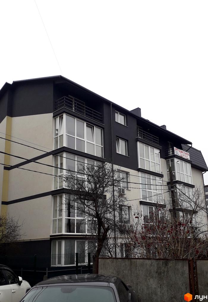 Зовнішній вигляд чотириповерхового будинку з великими вікнами та балконами, розташованого на вулиці Гайова, 7. На фасаді розміщено оголошення про продаж.