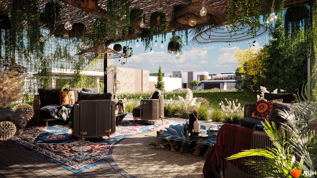 КМ Obriy Family Club – затишна тераса з плетеними меблями та зеленню, що виходить на зелену галявину з сучасними будинками.