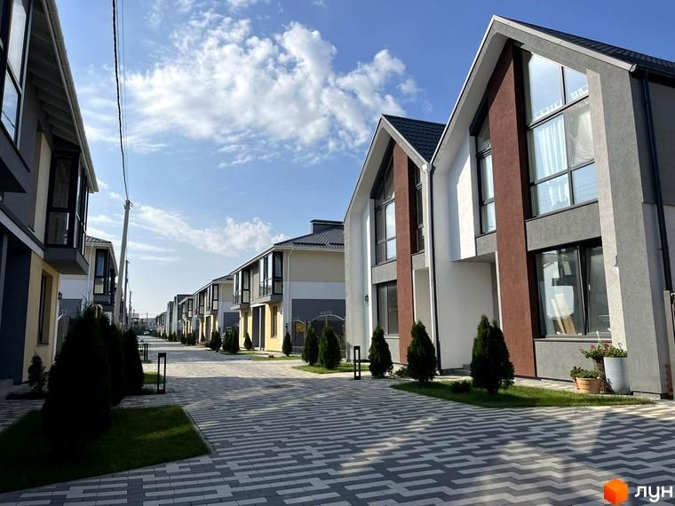 Котеджне містечко Beverly Hills Residence: фасади будинків з панорамними вікнами та прибудинкова територія з бруківкою та зеленими насадженнями.