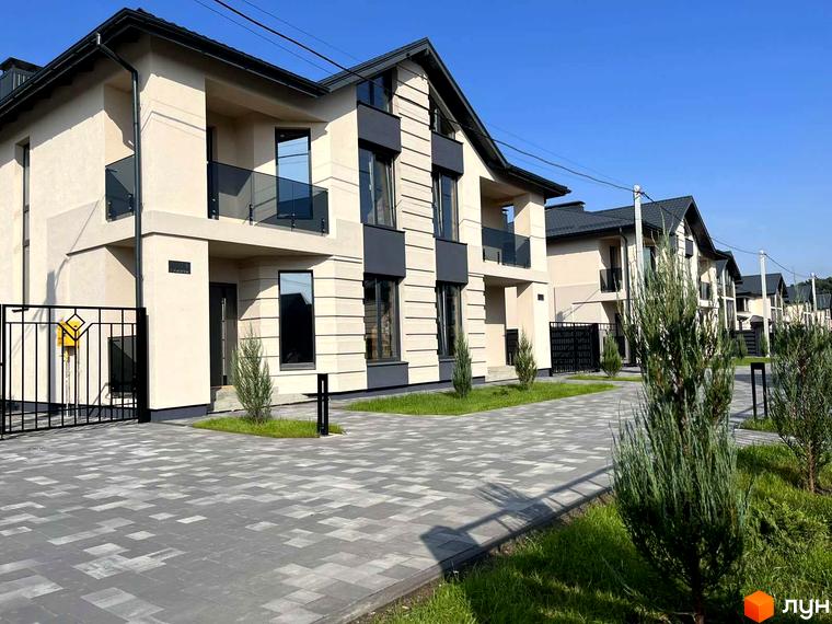 Котеджне містечко КМ Beverly Hills Residence: двоповерхові будинки світло-бежевого кольору з темними елементами фасаду, скляними балконами та вимощеною плиткою прибудинковою територією.