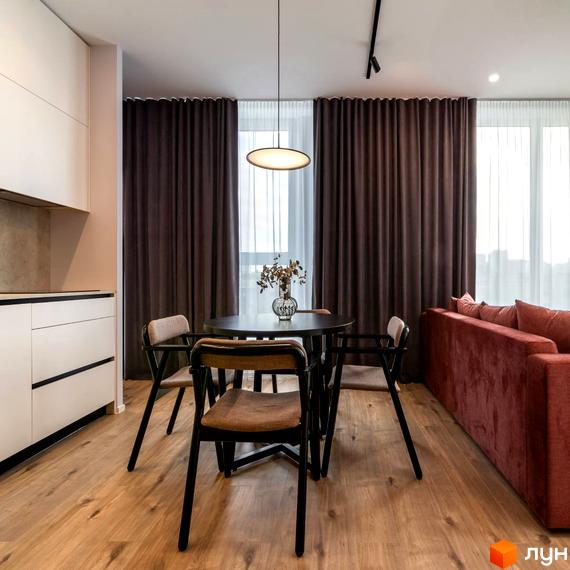 Інтер'єр квартири в ЖК Nebo: обідня зона з круглим столом та стільцями, поруч вітальня з диваном. Загальний вигляд кімнати.