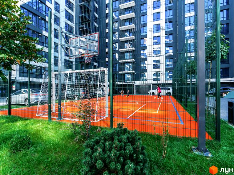 Житловий комплекс Comfort Park. Спортивний майданчик з баскетбольним кільцем та футбольними воротами на тлі багатоповерхових будинків.