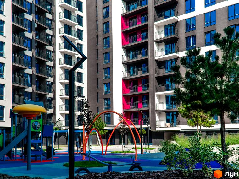 Зовнішній вигляд багатоповерхового будинку в Житловому районі Family Plaza. На території розташований дитячий майданчик.