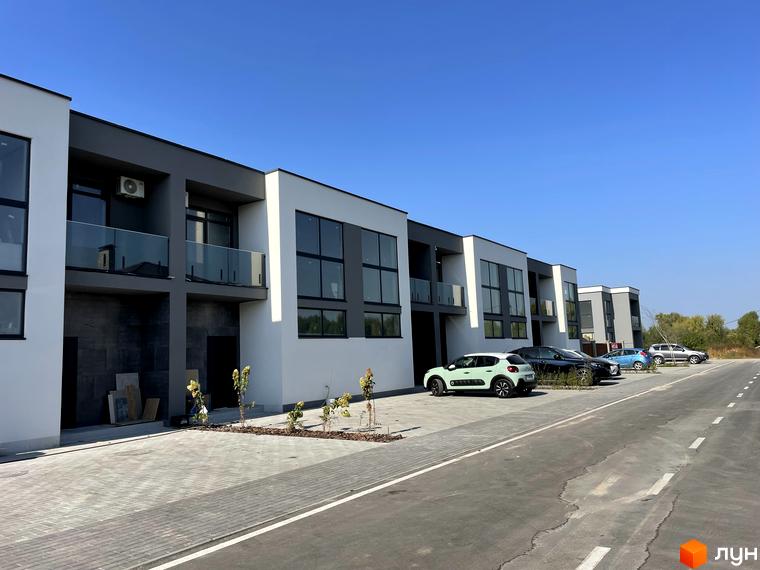 Котеджне містечко КМ Osocor House: фасади будинків з великими вікнами та балконами, парковка з автомобілями.