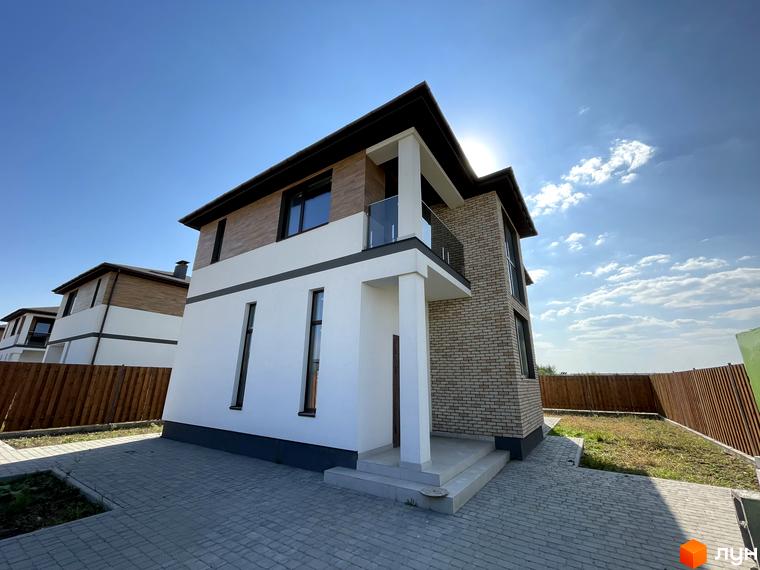Котеджне містечко КМ Osocor House: двоповерховий будинок з білою та цегляною обробкою, скляним балконом та вимощеною територією перед будинком.