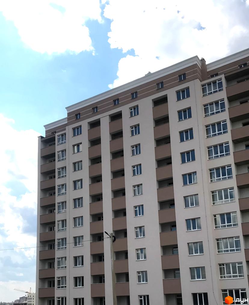 Зображення фасаду багатоповерхового будинку в Житловому комплексі Новобудова. Вигляд новобудови з вікнами та балконами.