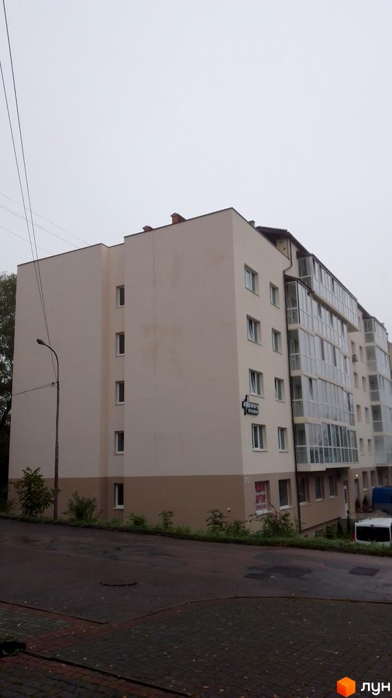 Зображення будинку по вулиці Стуса, 6а. Багатоповерхова будівля з великими вікнами та балконами, поруч видно зелені насадження.