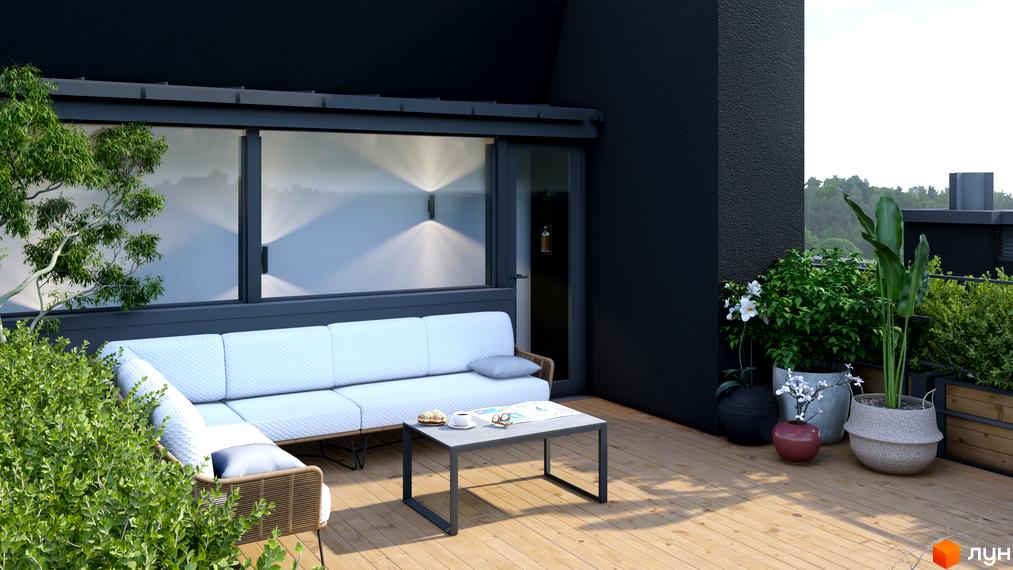 Сучасний балкон з диваном та кавовим столиком на дерев'яній терасі ЖК SOLOWAY. Зелені рослини та квіти в горщиках створюють затишну атмосферу.