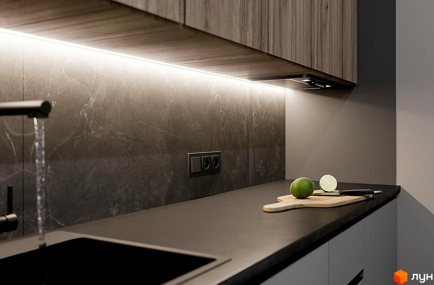 Вигляд кухні в Житловому комплексі SOLOWAY: темна стільниця, мийка та кухонне приладдя. Освітлення під верхніми шафами.