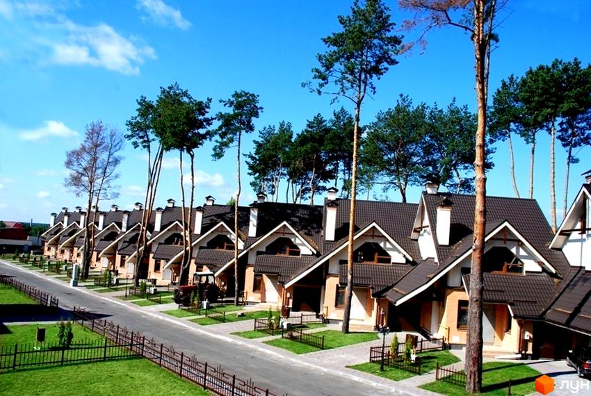 Зовнішній вигляд котеджного містечка КМ Ясні Зорі з зеленими насадженнями та прибудинковою територією.