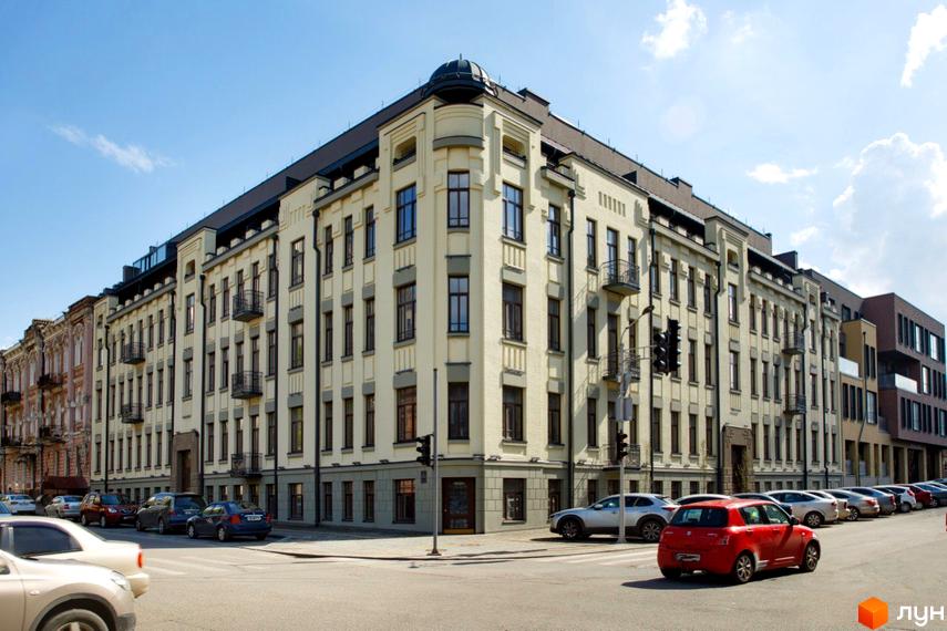 Житловий комплекс Троїцький. Багатоповерхова будівля з великою кількістю вікон та балконів. На вулиці припарковані автомобілі.