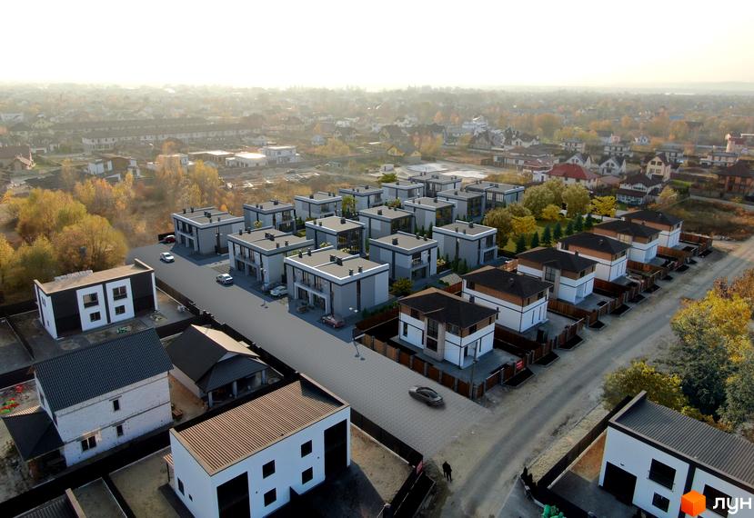 Вид зверху на Котеджне містечко GREAT OSOCOR Apartments: сірі та білі двоповерхові будинки з темними дахами. Подвір'я з бруківкою та газонами.