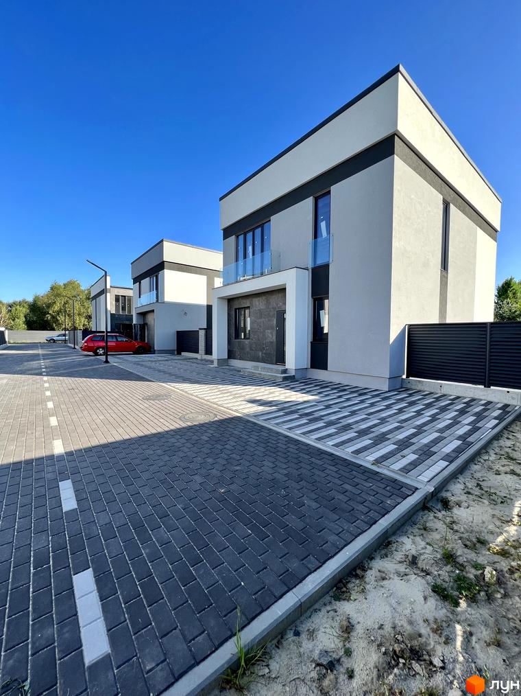 Зображення Котеджного містечка GREAT OSOCOR Apartments. Двоповерхові будинки з сірим оздобленням та облаштована прибудинкова територія.