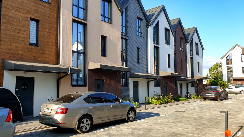 Таунхауси New Smart 6 з цегляним та штукатурним фасадом, вікнами в підлогу та прибудинковою територією з парковкою.