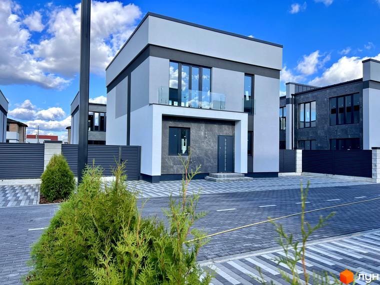 Зображення двоповерхового будинку в Котеджному містечку GREAT OSOCOR Apartments. На передньому плані зелені насадження та бруківка.