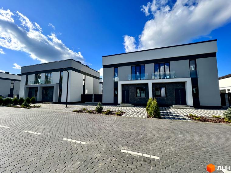 Котеджне містечко GREAT OSOCOR Apartments: двоповерхові будинки з сірими та білими фасадами, скляними балконами та вимощеною територією перед будинками.