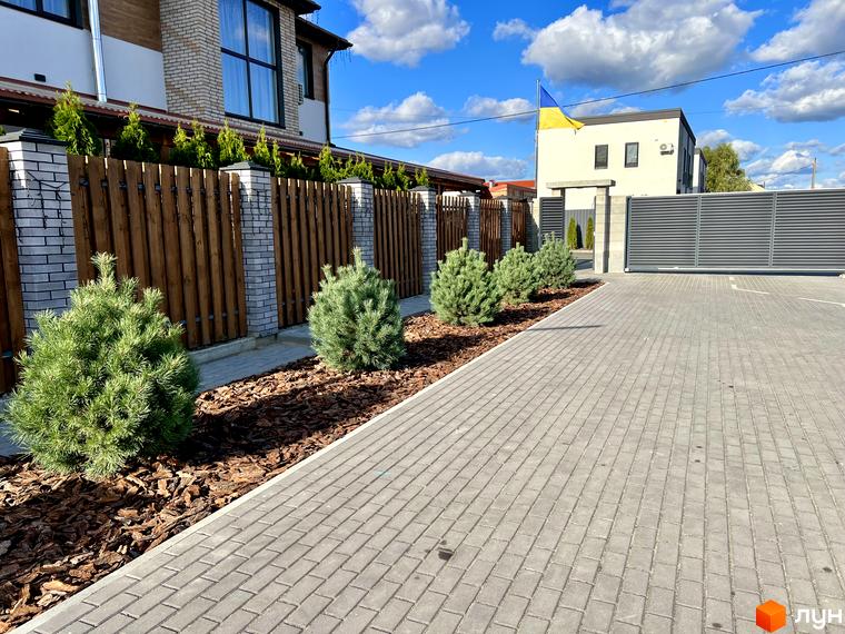Зовнішній вигляд Котеджного містечка GREAT OSOCOR Apartments. На передньому плані прибудинкова територія з ландшафтним дизайном.