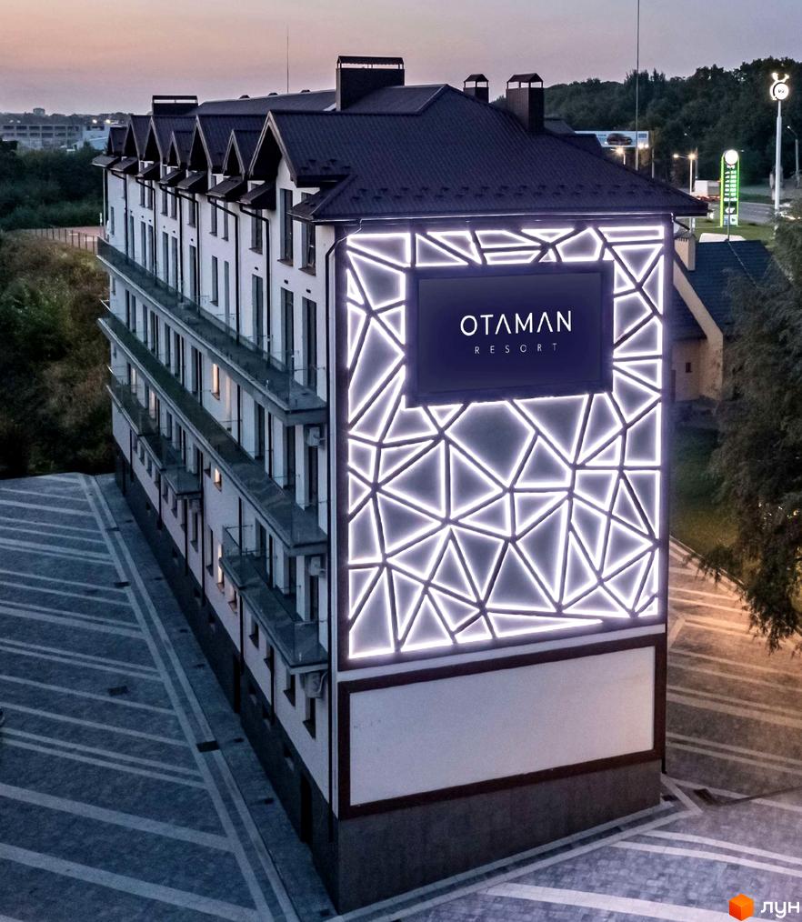 Зображення апарт-готелю OTAMAN Resort. Багатоповерхова будівля з темним дахом та великою вивіскою на фасаді.