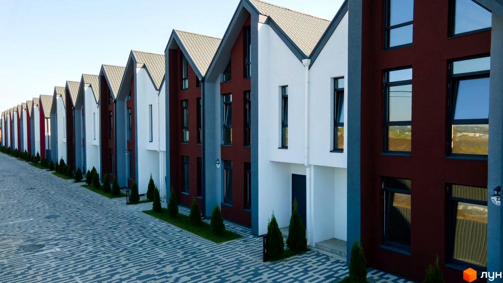 Котеджне містечко КМ Beverly Hills Residence: ряд сучасних будинків з білими та бордовими фасадами, сірими дахами та акуратною прибудинковою територією з зеленими насадженнями.