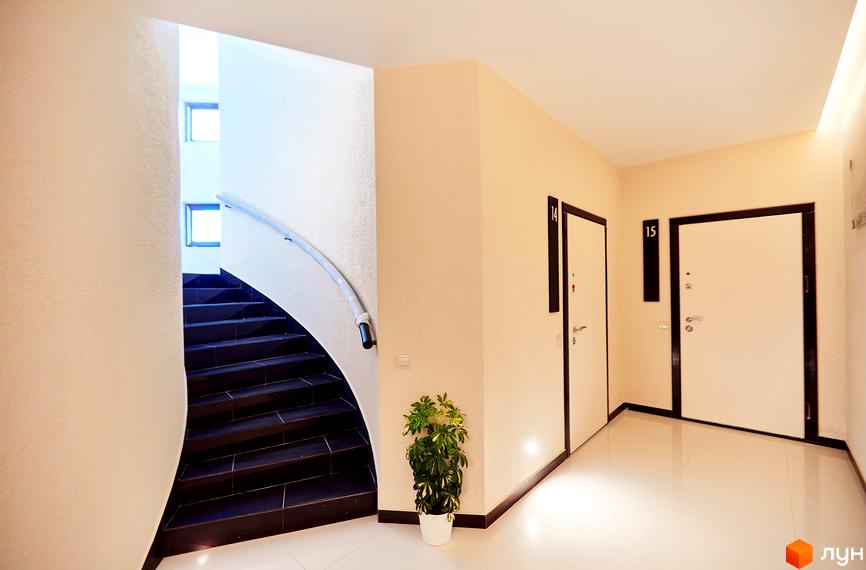 Житловий комплекс GREEN LAND: внутрішній простір зі сходовою кліткою та дверима. Світлий коридор та зручні сходи.