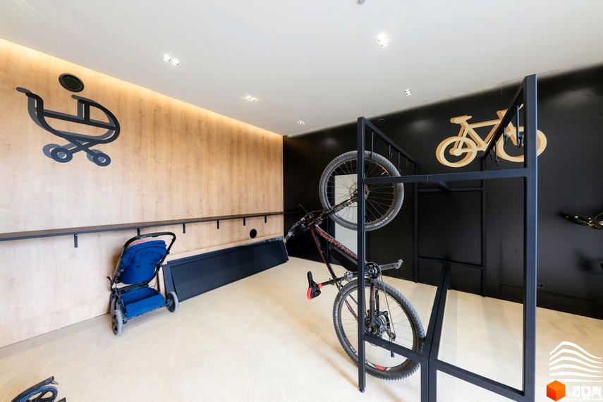 Житловий комплекс PARK LAND: сучасне сховище для велосипедів та дитячих візочків, розташоване на тлі дерев'яної стіни та чорної стіни з декором.