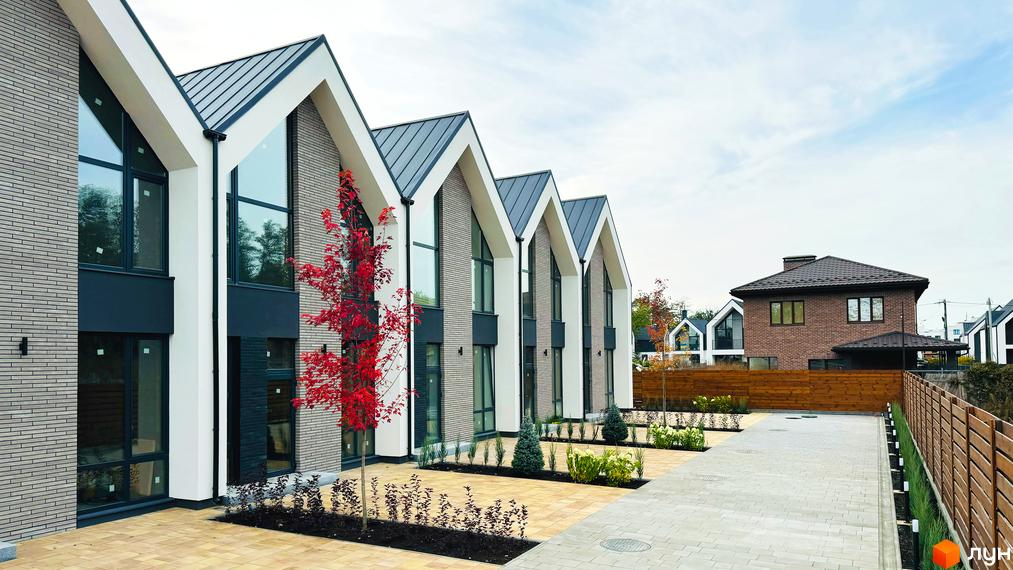 Таунхауси FreeDOM's: фасади з сірої цегли та темним дахом, великі вікна, прибудинкова територія з бруківкою та деревами.