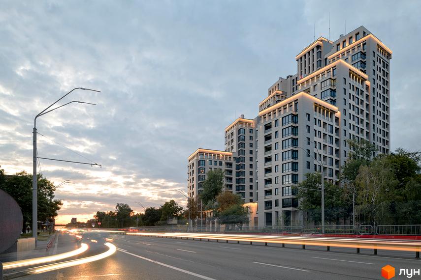 Житловий комплекс Crystal Park Tower з багатоповерховими будинками та підсвіченими фасадами, розташований біля дороги з автомобілями.