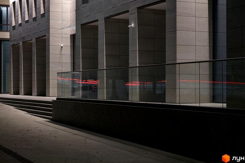 Сучасна архітектура ЖК Crystal Park Tower з скляними елементами та освітленням. Територія навколо новобудови має сходи та доріжки.