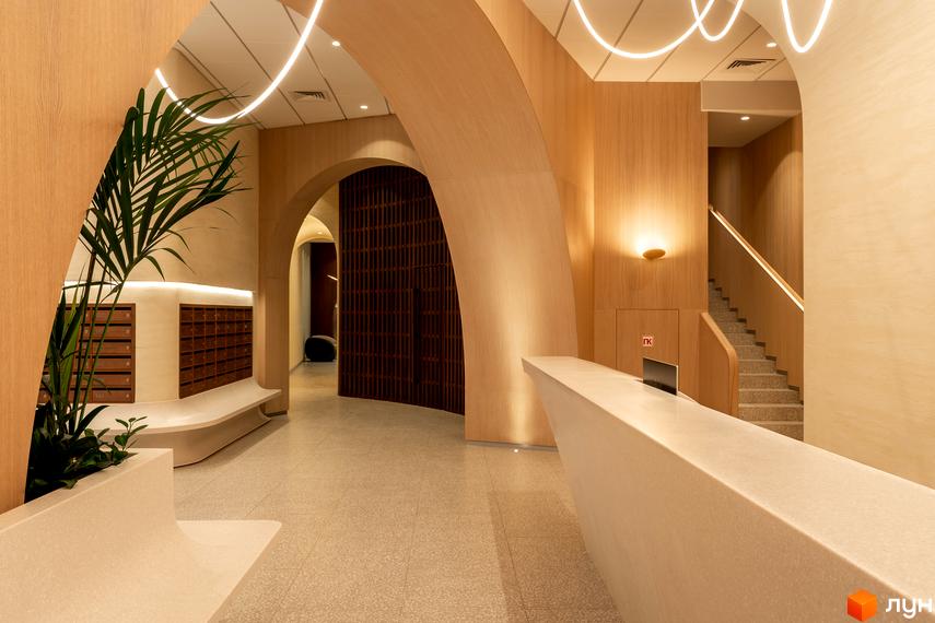 Інтер'єр лобі житлового комплексу Crystal Park Tower з дерев'яними арками, поштовими скриньками та сходовою кліткою.