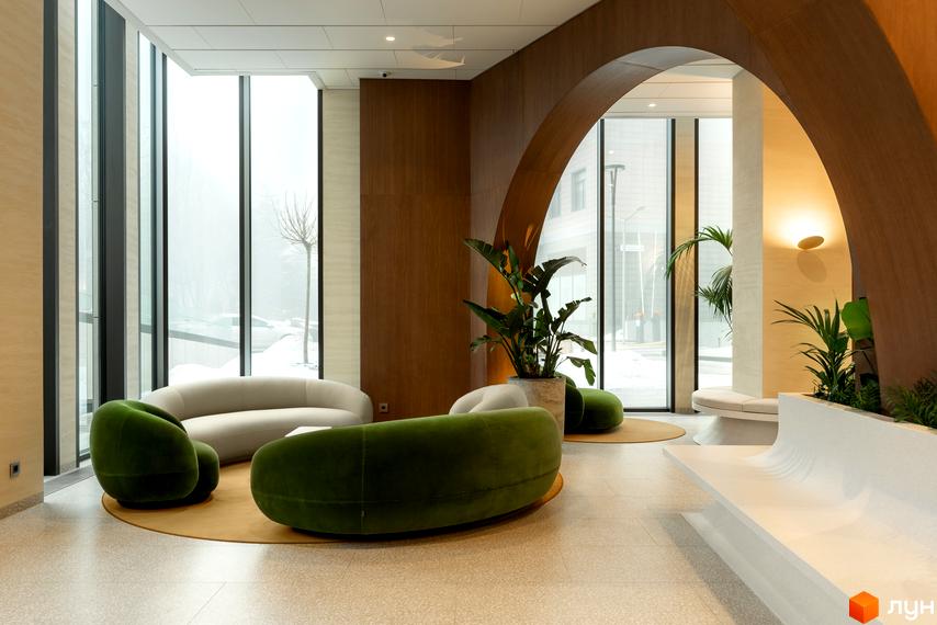 Інтер'єр лобі житлового комплексу Crystal Park Tower з дизайнерськими диванами та рослинами. Просторий хол з великими вікнами та аркою.